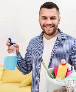 smiley-man-holding-bucket-with-cleaning-products_23-2148456962